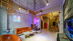A modern interior with a sofa, a coffee table, and a unique orange chair. - Tainan Anping High Chill B&B (Tainan)