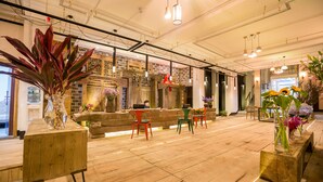 A spacious lobby with a wooden floor, a reception desk, and several chairs. - Maosao Inn (Zhangjiajie)