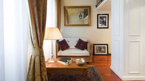 A living room with a sofa, a lamp, a coffee table, and framed pictures on the wall. - Old Tower Ponte Vecchio Suite A (Firenze)