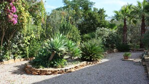 A garden with various plants and a gravel path. - House ideal for families with children, large garden with pool and playground (Can Picafort)