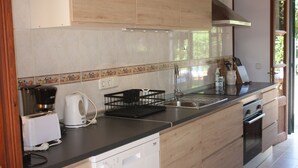 A modern kitchen with a dishwasher, coffee maker, and a sink. - House ideal for families with children, large garden with pool and playground (Can Picafort)
