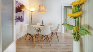 A dining area with a white table, white chairs, and a hanging light fixture. - Amazing Terrace in the Center by Hello Homes Sitges (Sitges)