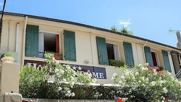 A hotel with a sign reading "HOTEL VENDOME" and a balcony with flowers.