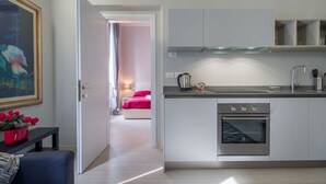 Una cocina moderna con horno empotrado, un lavamanos y una repisa de vidrio sobre la encimera.