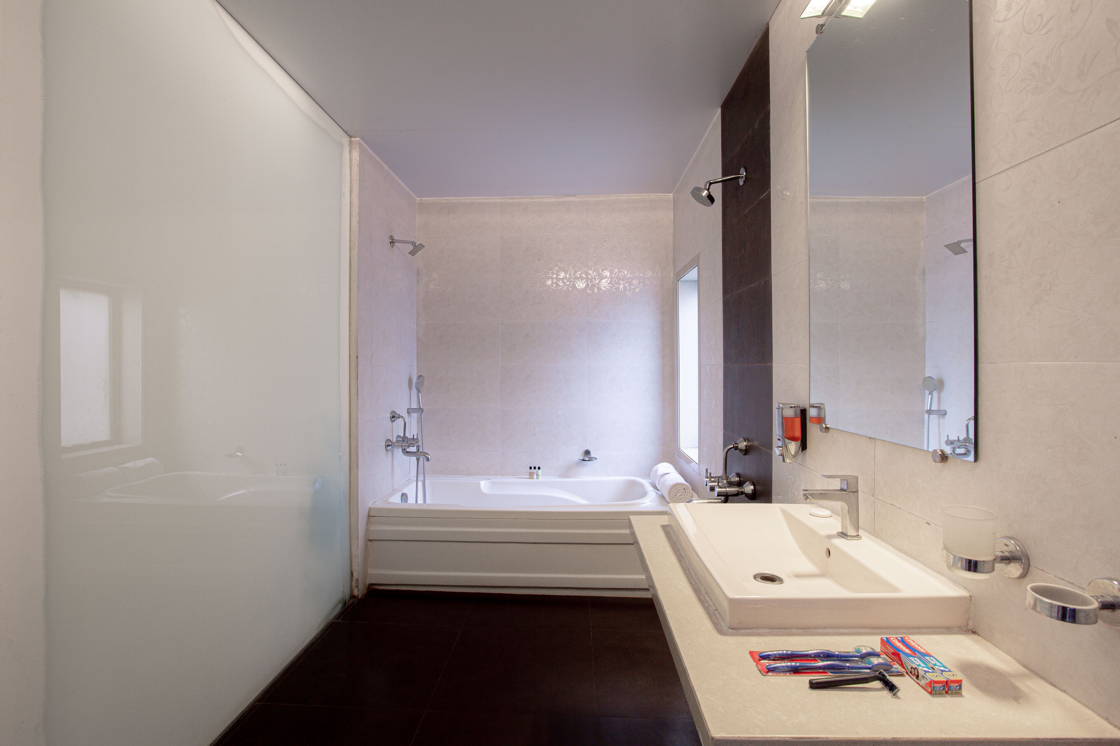 Ein modernes Badezimmer mit einer Badewanne, einem Waschbecken und einem großen Spiegel.