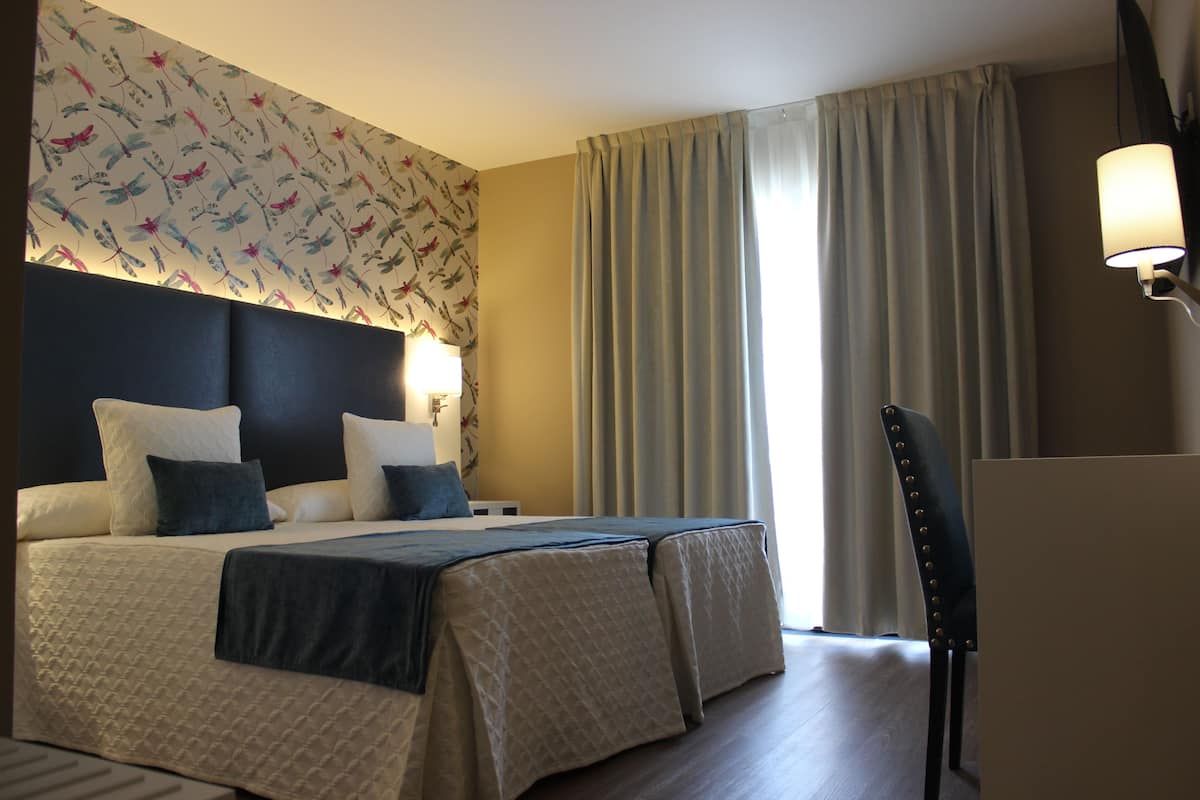 Ein Hotelzimmer mit einem großen Bett, einem Schreibtisch und einem Stuhl.
