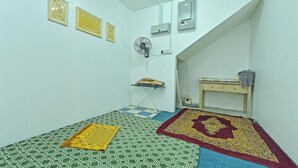 A small, clean room with a checkered floor, a fan, and a bed with a patterned bedspread. - F Hotel Bayan Lepas (George Town)