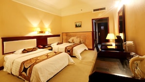 Una habitación de hotel con dos camas, una mesita de noche, una lámpara, un espejo y una cafetera.
