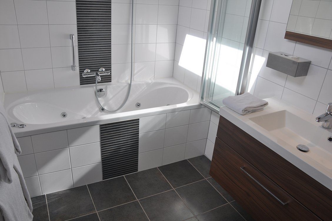 A modern bathroom with a freestanding bathtub, a vanity with a sink, and a mirror.