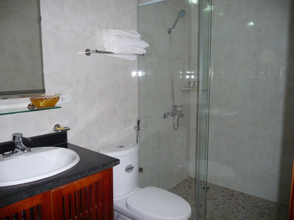 A bathroom with a white sink, a toilet, and a glass-enclosed shower area.