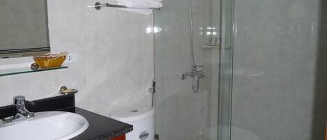 Ein Badezimmer mit einem weißen Waschbecken, einer Toilette und einer Duschkabine.