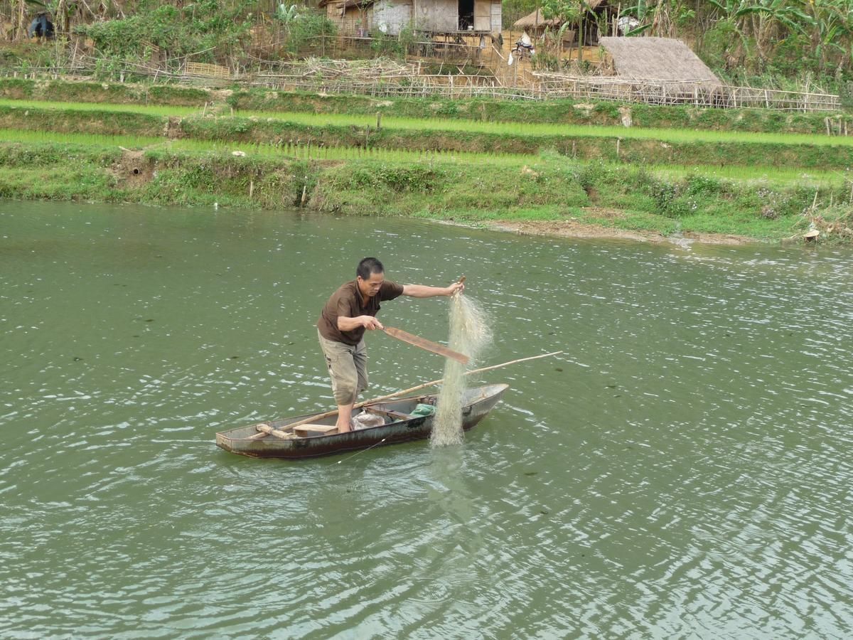 Una persona pescando en un bote sobre un río.