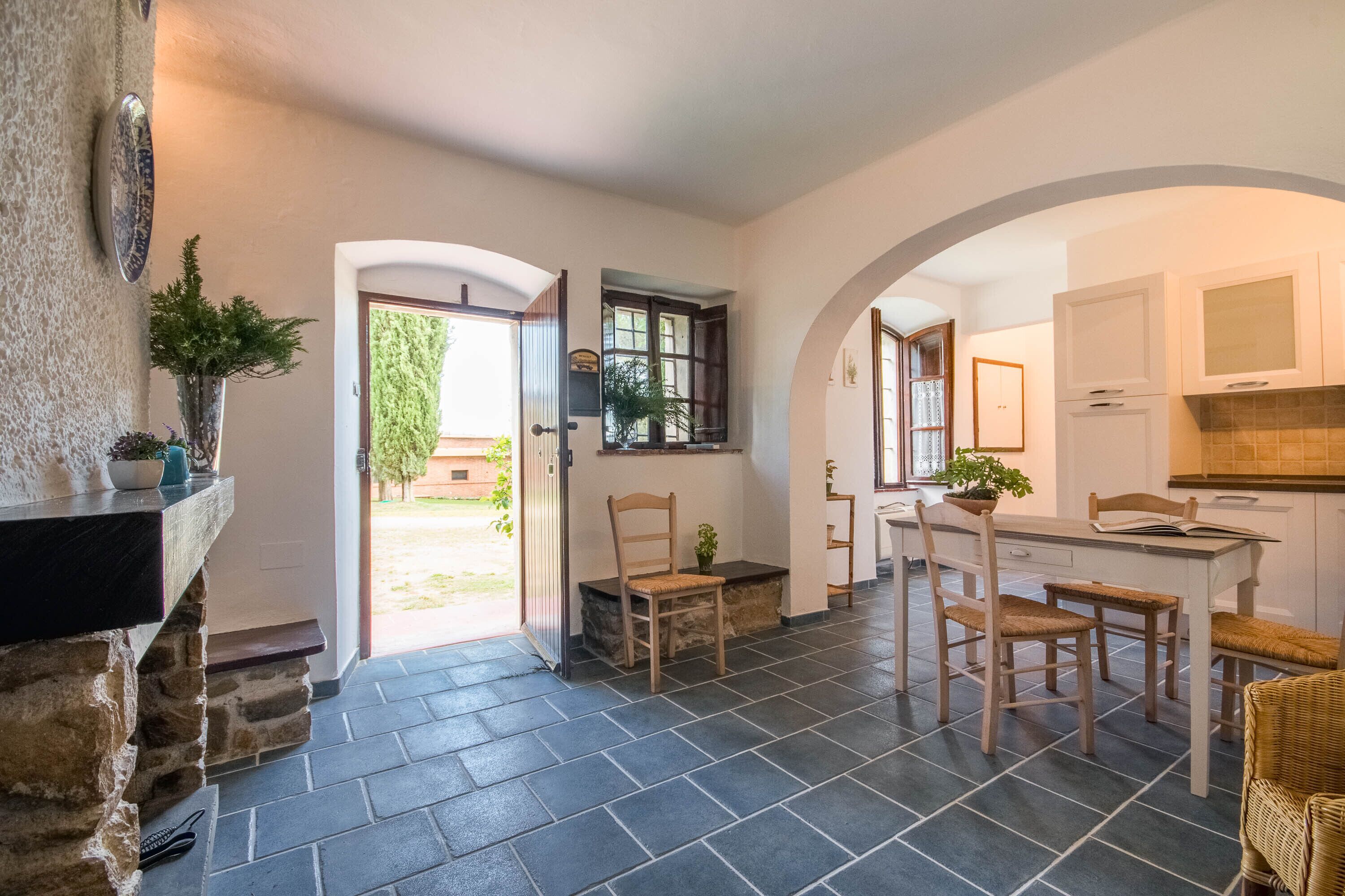 A kitchen with a dining area, stone walls, and a view of the outdoors.