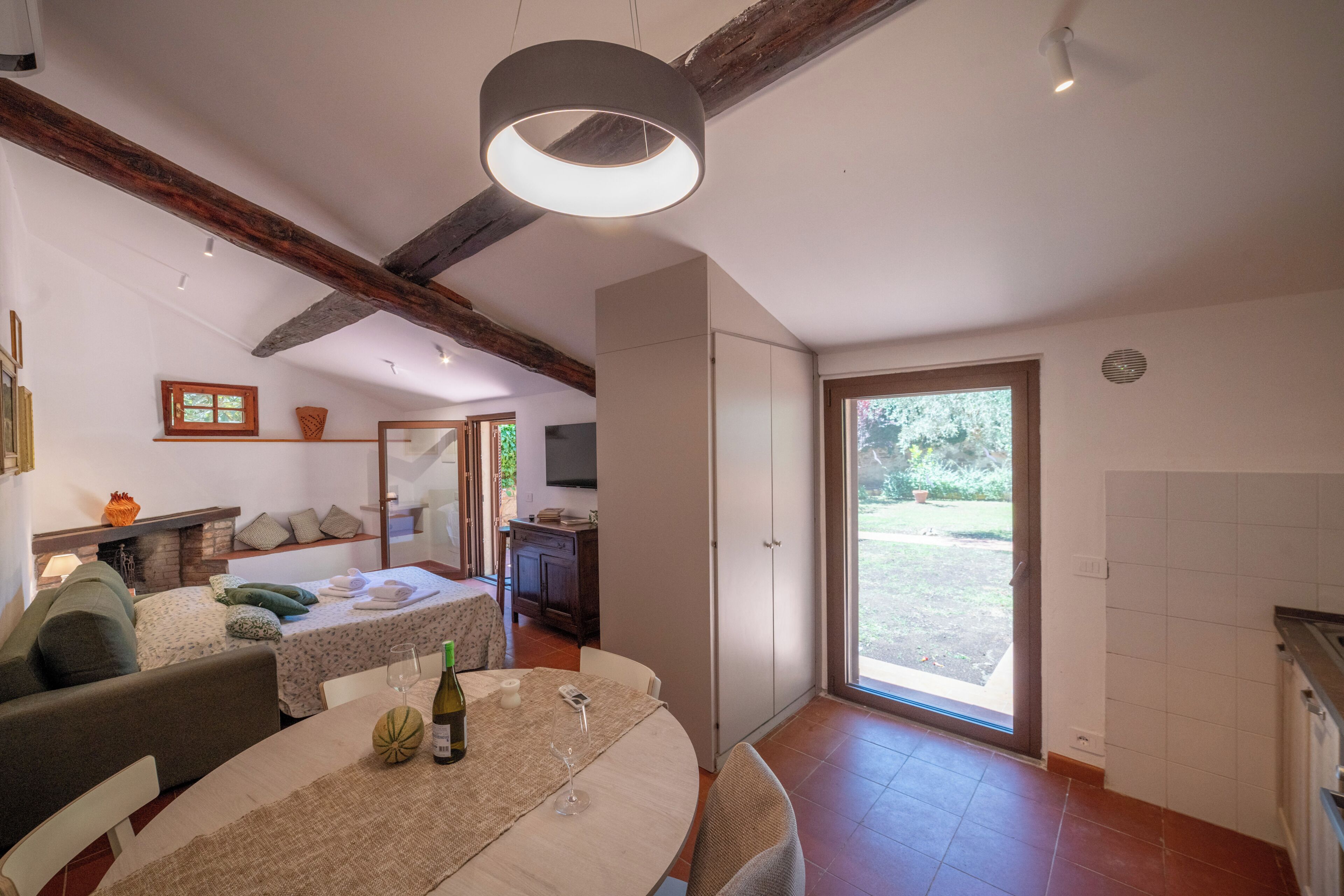 A spacious living area with a dining table, sofa, and a large window.