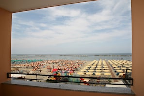A balcony with a view of a beach with numerous umbrellas and sun loungers. - Hotel Riposo (Gatteo)