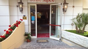 The entrance of Hotel Riposo with a stone-paved entrance, a red flower planter, and a sign indicating a Wi-Fi zone. - Hotel Riposo (Gatteo)