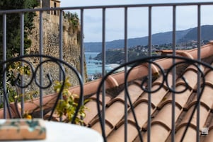 A balcony with terracotta roof tiles and a metal railing.