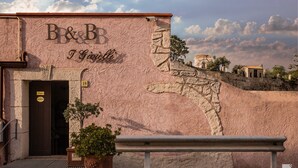 A building with a sign reading "B&B I Giolitti" and a stone wall with a relief sculpture.