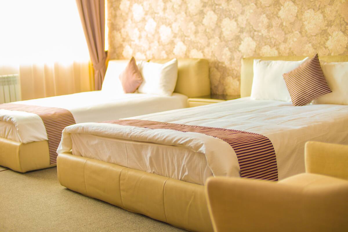 Ein Hotelzimmer mit zwei Betten, einem Sofa und Teppichboden.