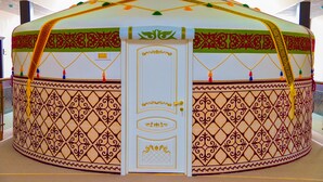 Une yourte traditionnelle dotée d’une porte décorative et de motifs complexes.