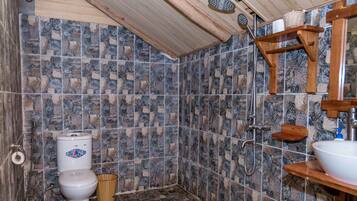 Een douche, pantoffels, een bidet, handdoeken