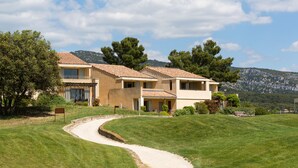 A two-story house with a curved driveway, surrounded by well-maintained grass and trees. - Le Domaine de Provence Country Club (Saumane-de-Vaucluse)
