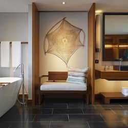 Enjoy a relaxing soak in the bathtub, accompanied by a comfortable bench and a large mirror.