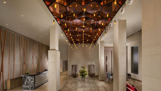 A spacious lobby with a geometric patterned floor, a reception desk, and two seating areas with chairs. - Sarovar Premiere Jaipur (Jaipur)