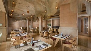 A spacious restaurant with high ceilings, modern furniture, and a warm ambiance. - Sarovar Premiere Jaipur (Jaipur)