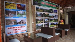 A wall with multiple informational posters and a sign offering a free map and bus tickets. - Tam Coc Lakeside Homestay (Nam Hoa Lu)