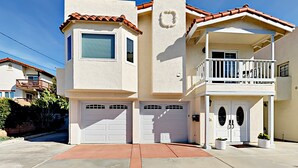 Une maison à deux étages avec un balcon, un garage et une porte d’entrée.