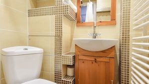 A bathroom with a toilet, sink, and tiled walls. - ShortStayPoland Leszno - B53 (Warsaw)