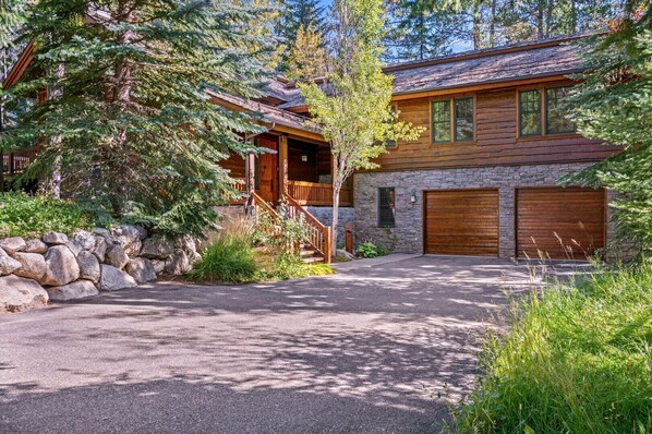 A log cabin with a stone foundation, a wooden porch, and a stone wall. - RMR: Granite Ridge Homestead 3091 in Teton Village (Teton Village)
