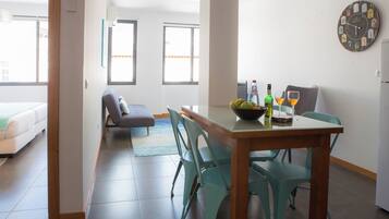 Un espacio moderno con comedor, sofá y un gran reloj de pared.