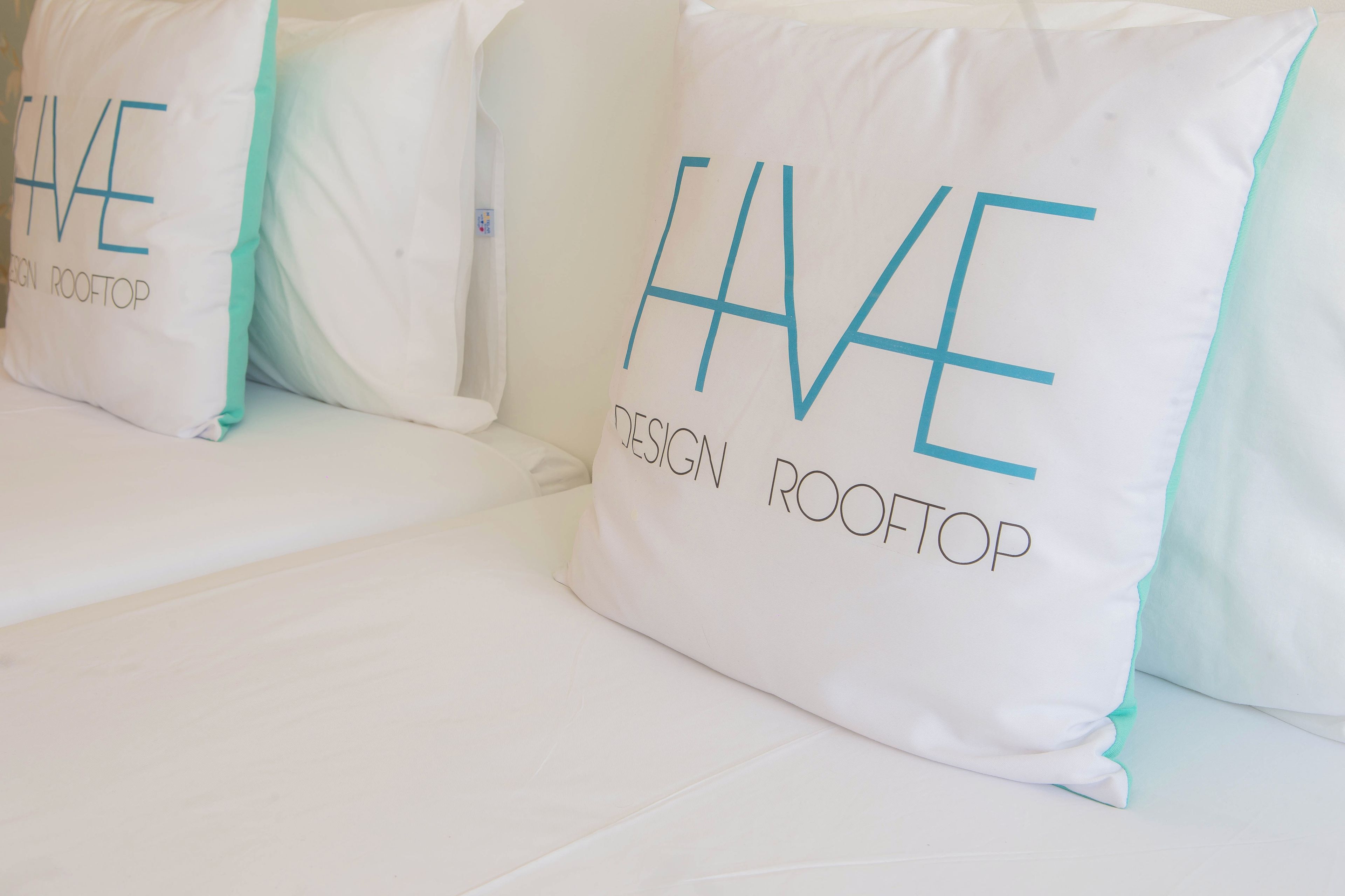 A row of white pillows with 'HAVE DESIGN ROOFTOP' text.