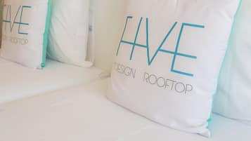Une rangée de coussins blancs avec l’inscription « HAVE DESIGN ROOFTOP ».