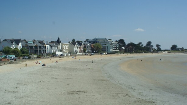 A beach with buildings in the background. -  Longére A Larmor-Plage, authentic charm of the stone. (Larmor-Plage)