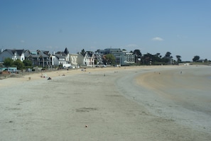 A beach with buildings in the background. -  Longére A Larmor-Plage, authentic charm of the stone. (Larmor-Plage)