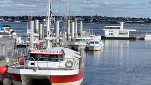 A harbor with boats docked, including a prominent red and white boat named "LORIENT-ILE DE GROIX". -  Longére A Larmor-Plage, authentic charm of the stone. (Larmor-Plage)