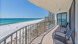 A balcony with a view of a beach and ocean.