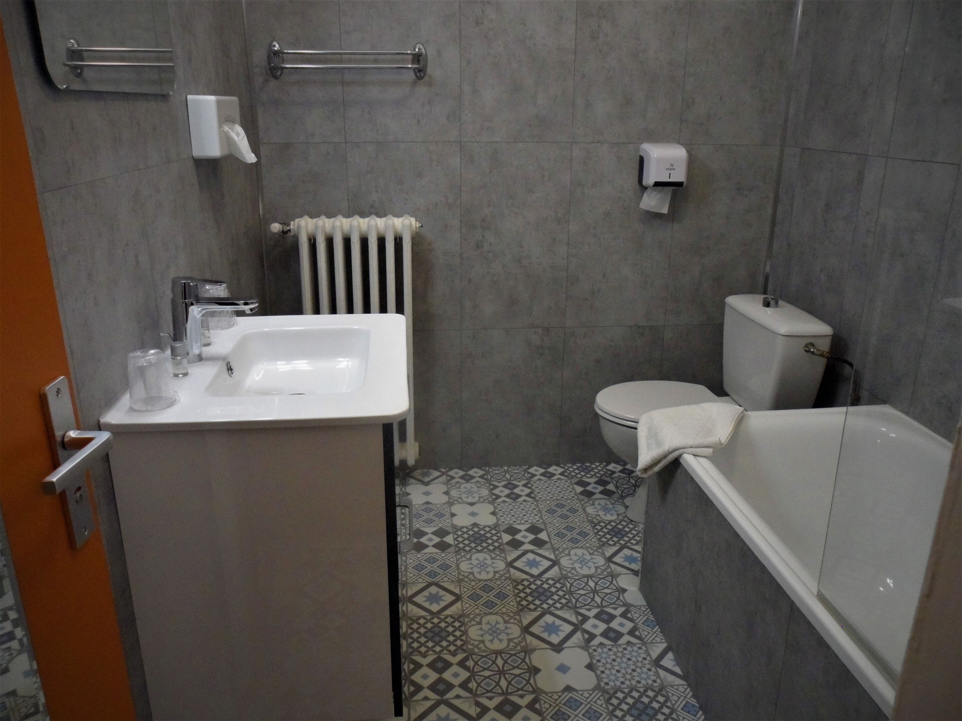 Un baño con lavamanos, inodoro y bañera.