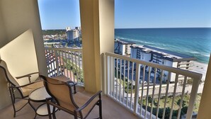 A balcony with a view of the ocean and buildings.