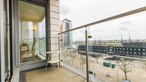 A balcony with a view of a cityscape, including a hotel and buildings. - Grand Vista by Austin David Apartments (London)