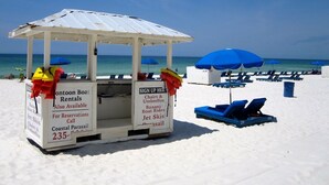 A beachside kiosk with a sign for boat rentals and parasailing.