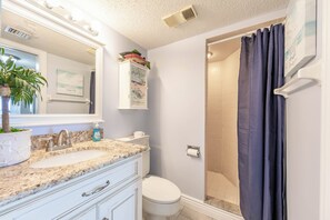 Un baño con lavamanos, inodoro y ducha.