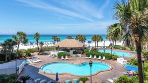 A resort with a pool, beach, and ocean view.