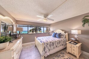 Un dormitorio con cama, cómoda, mesita de noche y vista al océano.