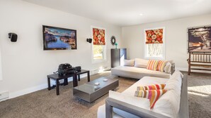 Een moderne woonkamer met een bank, salontafel en een schilderij aan de muur.