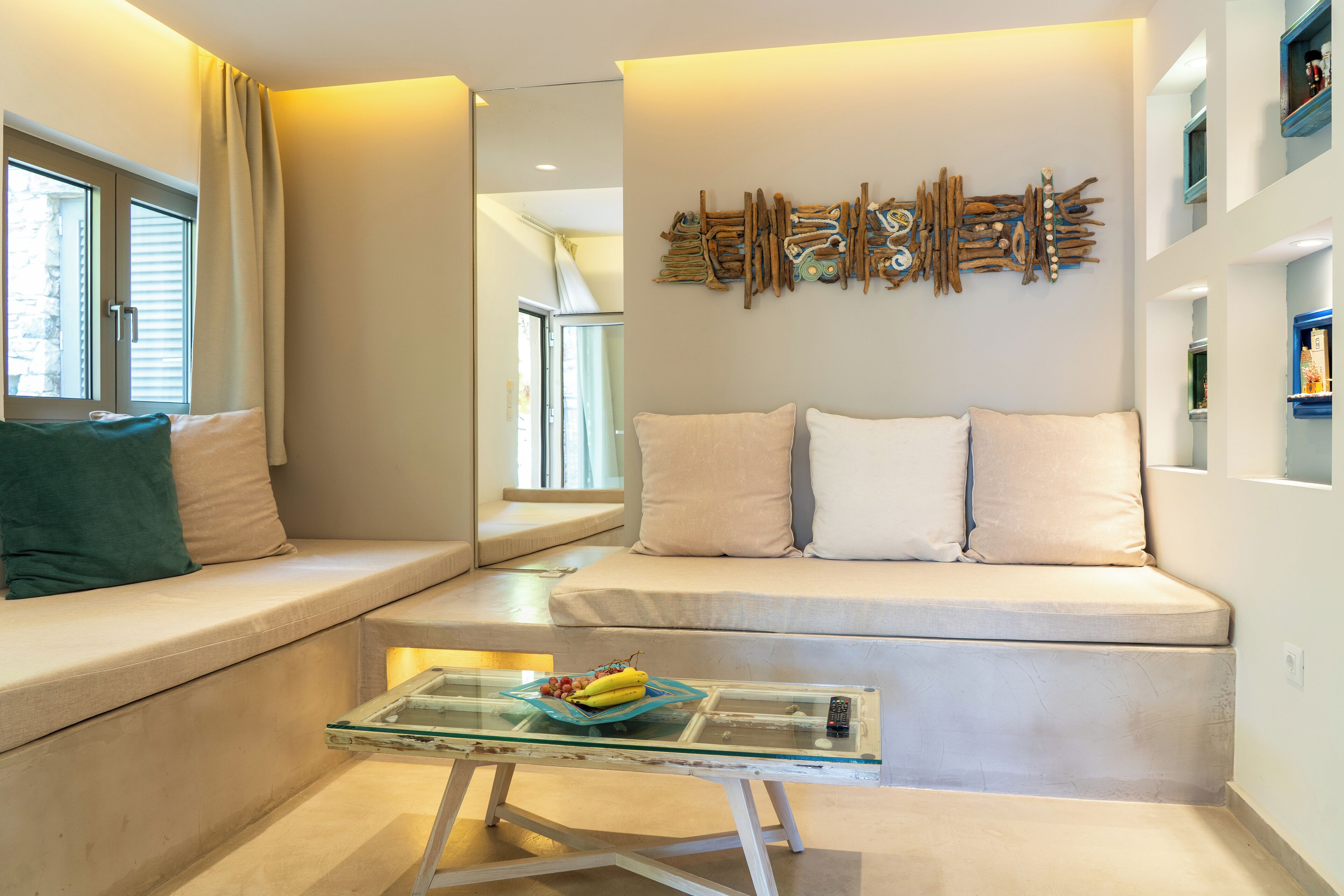 A modern living room with a sofa, a glass coffee table, and a wall art piece.