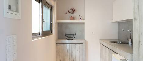 A compact kitchen with a window, a sink, and a small countertop.